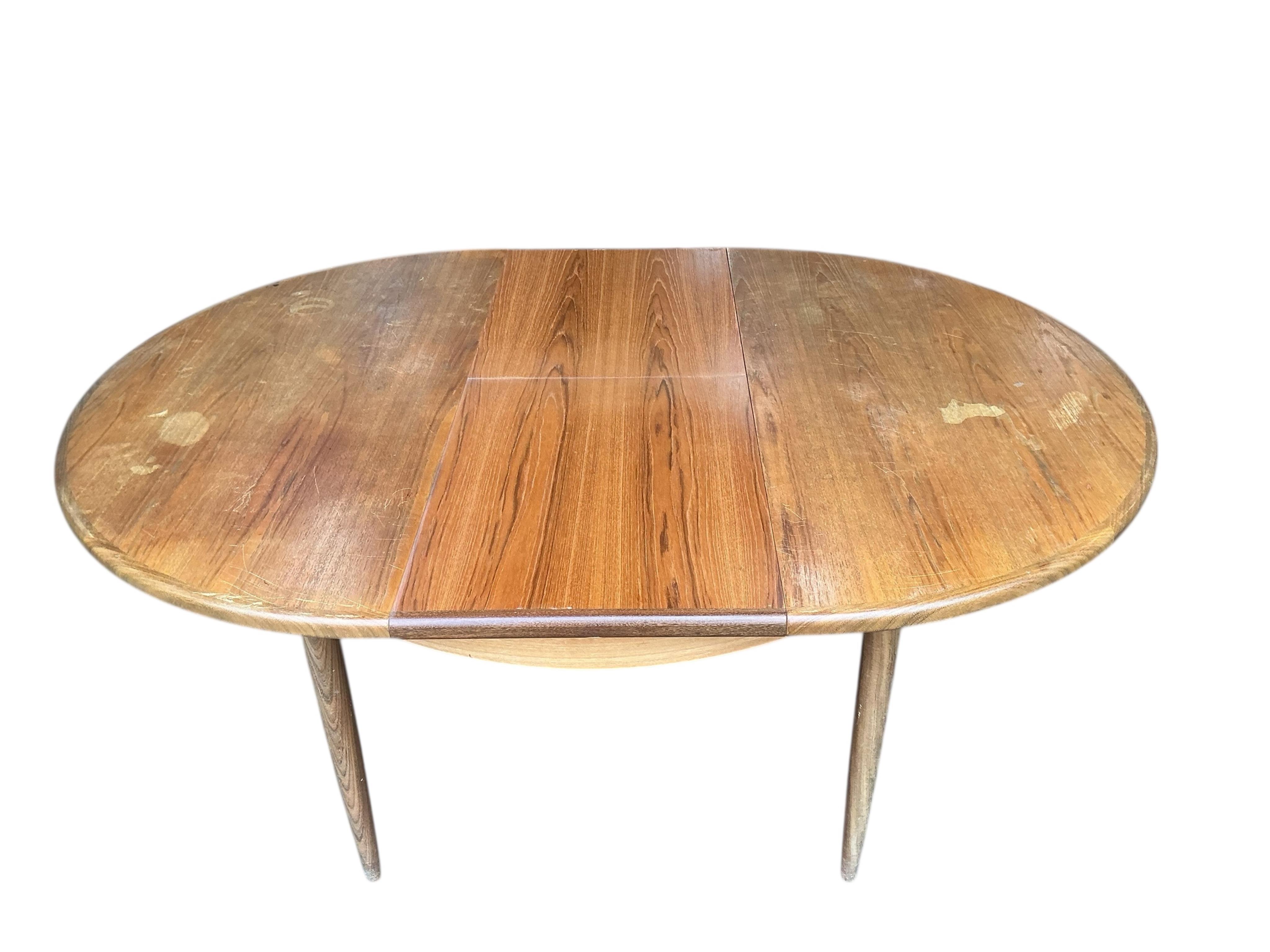 A mid century G Plan Fresco teak extending dining table, diameter 160cm, height 74cm, and four chairs